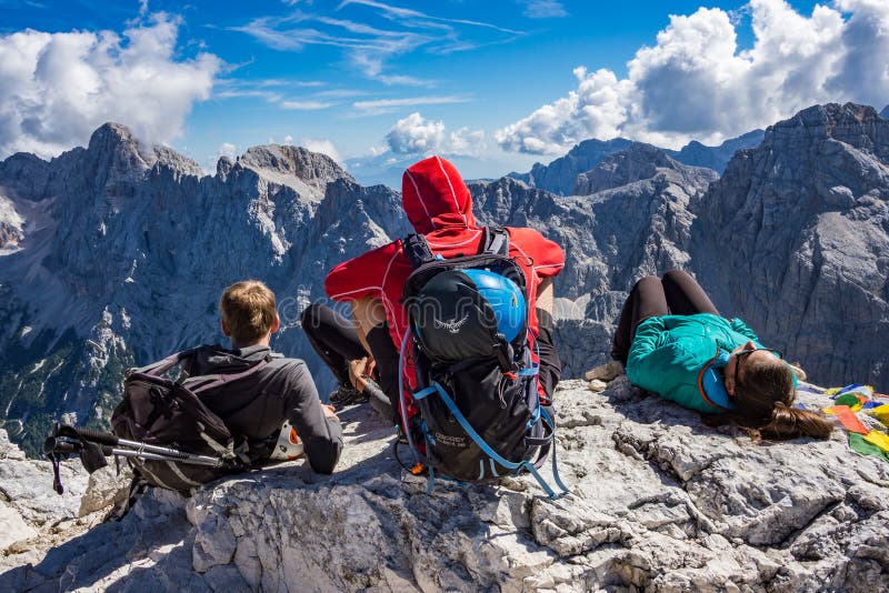 Trzy alpinisty siedzi na skale na wierzchołku Prisojnik góra fotografia royalty free Trzy alpinisty siedzi na skale na wierzchołku Prisojnik góra fotografia royalty free