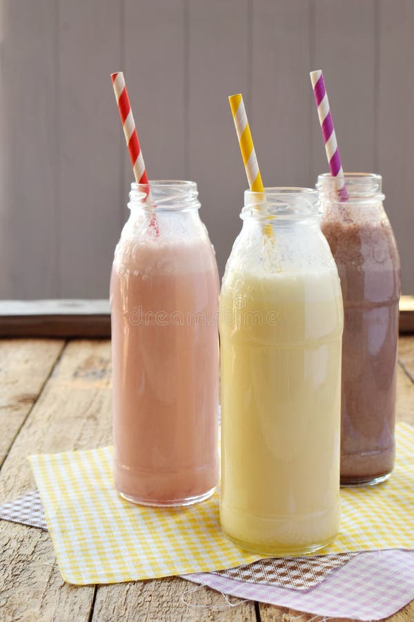 Trzy butelka r?? norodni milkshakes czekolada, truskawka i wanilia, Zdrowy smoothie z s? om? Smakowici dojnego potrz?? ni? cia koktaj zdjęcia stock