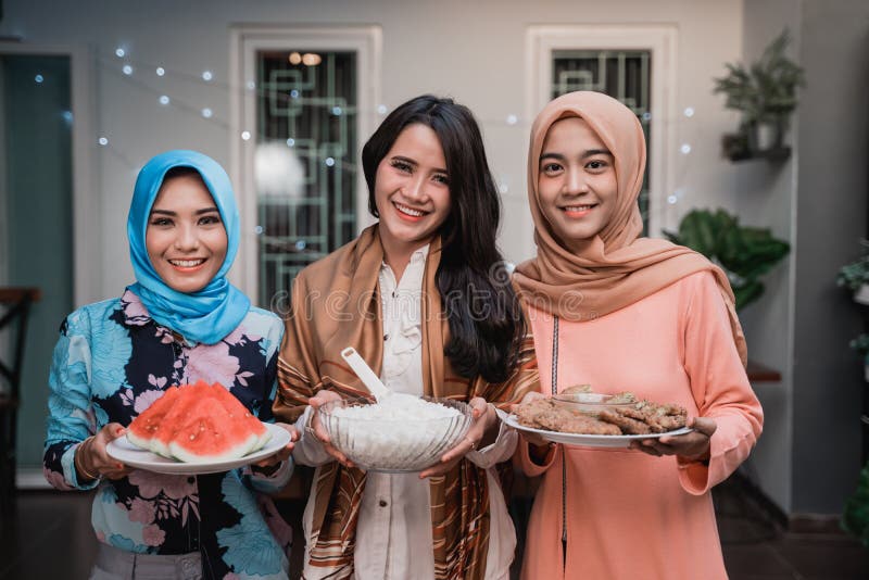 Three hijab women preparing food to serve when breaking fast with friends at home. Three hijab women preparing food to serve when breaking fast with friends at home