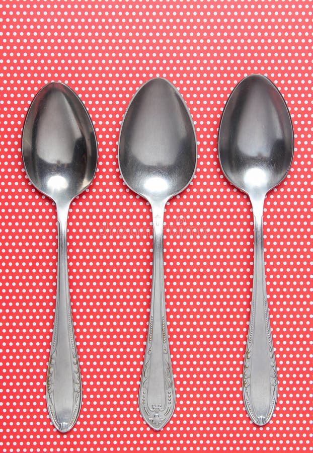 Trzy metal łyżki na tablecloths w polek kropkach Odgórny widok zdjęcie stock Trzy metal łyżki na tablecloths w polek kropkach Odgórny widok zdjęcie stock