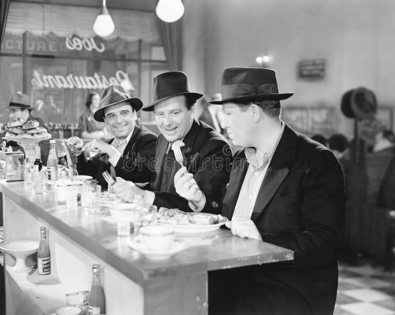 Three men sitting at the counter of a diner (All persons depicted are no longer living and no estate exists. Supplier grants that there will be no model release issues.). Three men sitting at the counter of a diner (All persons depicted are no longer living and no estate exists. Supplier grants that there will be no model release issues.)