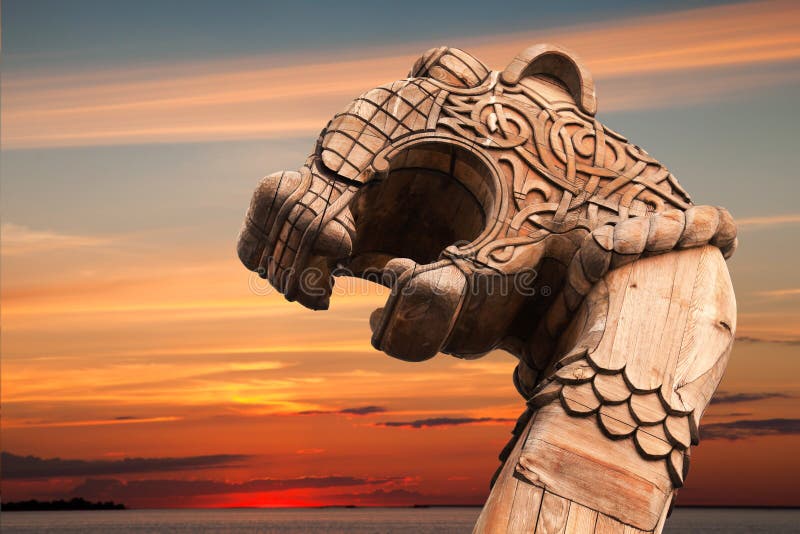 Carved wooden dragon on the bow of Viking ship above evening cloudy sky. Carved wooden dragon on the bow of Viking ship above evening cloudy sky