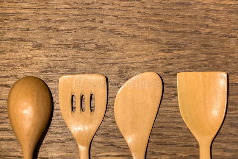 Image of a set of kitchen utensils including wooden spoon, spatulas and slotted turner in a rustic wood background. Image of a set of kitchen utensils including wooden spoon, spatulas and slotted turner in a rustic wood background.