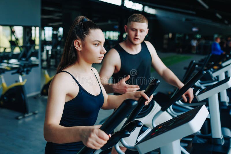 Tränare för träning som leder en dynamisk arbetsgruppssession på gymmet royaltyfria bilder