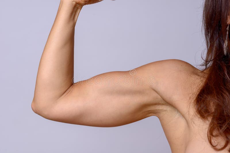 Tränga sig in den mogna kvinnan för den starka passformen som böjer hennes arm royaltyfri bild Tränga sig in den mogna kvinnan för den starka passformen som böjer hennes arm royaltyfri bild