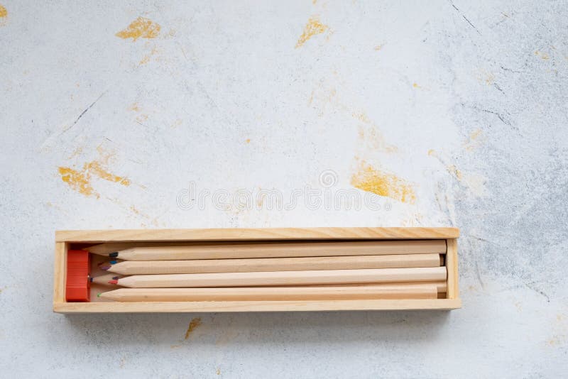 Wooden pencil case with colour pencils on a creativ grey background for back to school. Wooden pencil case with colour pencils on a creativ grey background for back to school