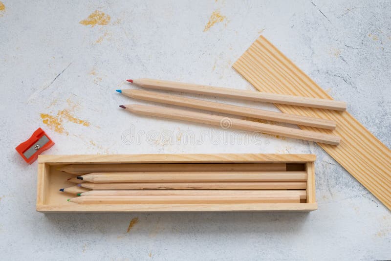 Wooden pencil case with colour pencils on a creativ grey background for back to school. Wooden pencil case with colour pencils on a creativ grey background for back to school