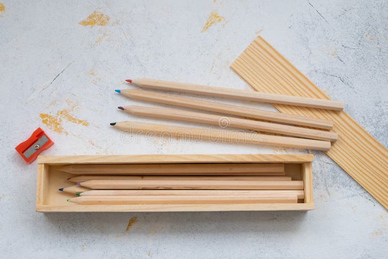 Wooden pencil case with colour pencils on a creativ grey background for back to school. Wooden pencil case with colour pencils on a creativ grey background for back to school