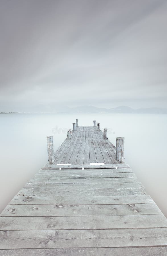 Träpir på laken i en molnig och dimmig mood. arkivfoto Träpir på laken i en molnig och dimmig mood. arkivfoto