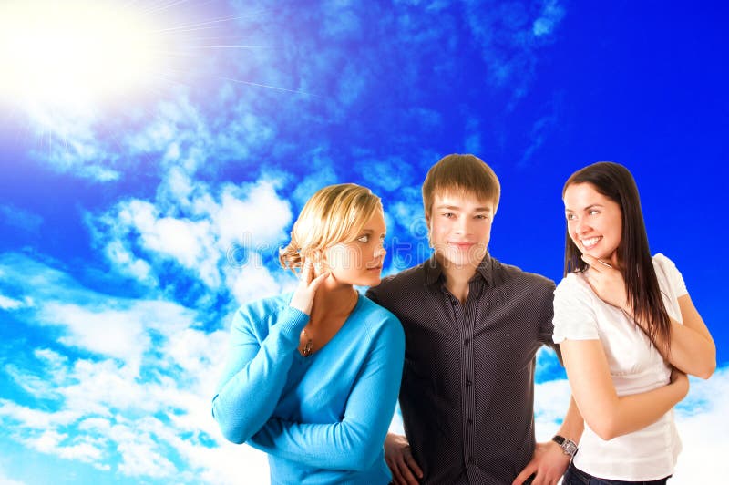 Três amigos adolescentes ao ar livre, sobre o céu azul fotografia de stock Três amigos adolescentes ao ar livre, sobre o céu azul fotografia de stock