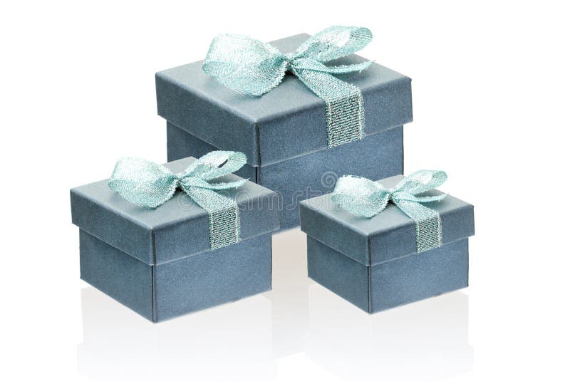 Three gift gray with a greenish tinge boxes isolate on a white background, close-up, reflection. Three gift gray with a greenish tinge boxes isolate on a white background, close-up, reflection.