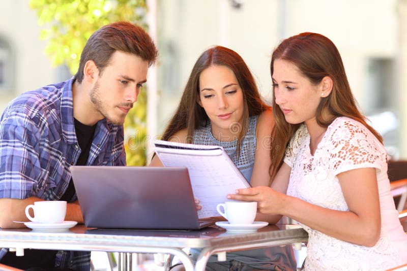 Três estudantes que aprendem junto em uma cafetaria foto de stock royalty free Três estudantes que aprendem junto em uma cafetaria foto de stock royalty free
