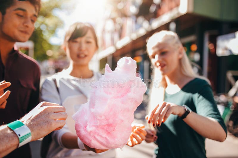 Três jovens que compartilham do candyfloss do algodão imagens de stock royalty free Três jovens que compartilham do candyfloss do algodão imagens de stock royalty free