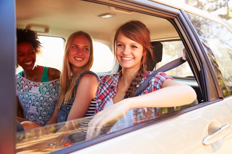 Três mulheres que sentam-se em Seat traseiro do carro na viagem por estrada foto de stock royalty free Três mulheres que sentam-se em Seat traseiro do carro na viagem por estrada foto de stock royalty free