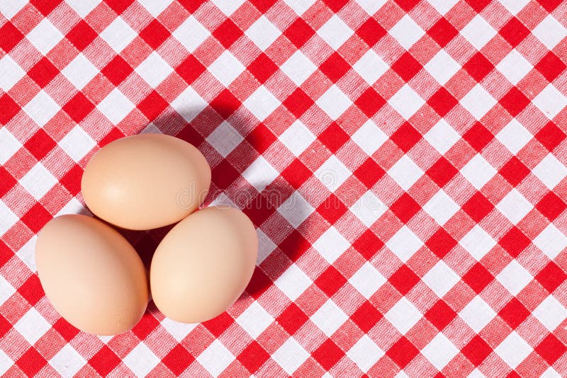 Três ovos no tablecloth do piquenique imagem de stock royalty free Três ovos no tablecloth do piquenique imagem de stock royalty free