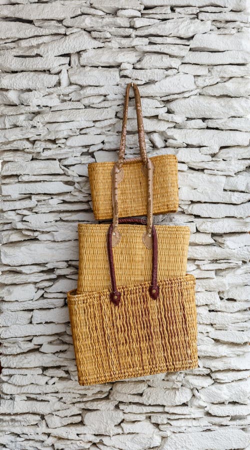Three wicker bags hanging on a rugged and white wall. Three wicker bags hanging on a rugged and white wall