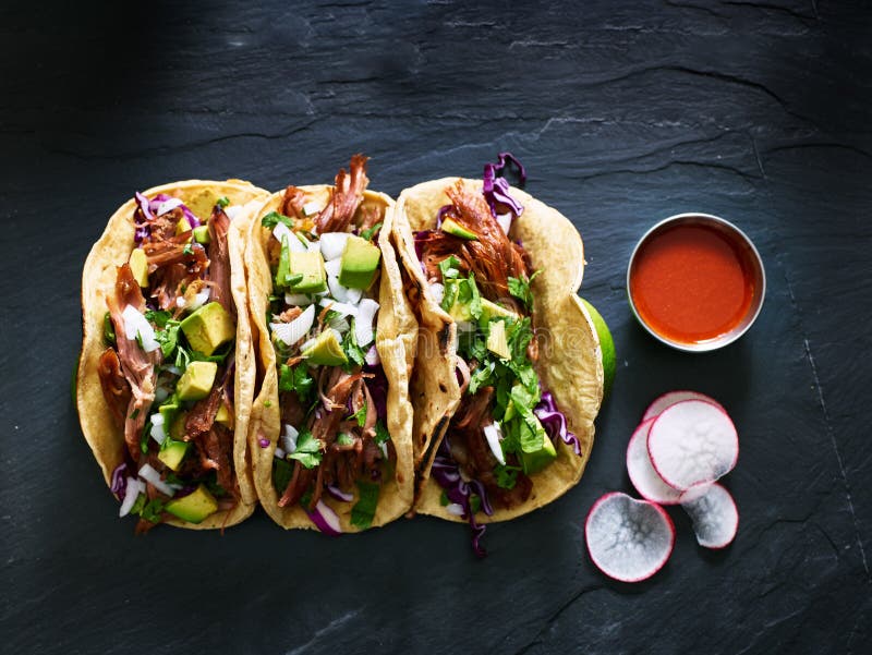 Three mexican pork carnitas tacos flat lay composition from bird`s eye view. Three mexican pork carnitas tacos flat lay composition from bird`s eye view