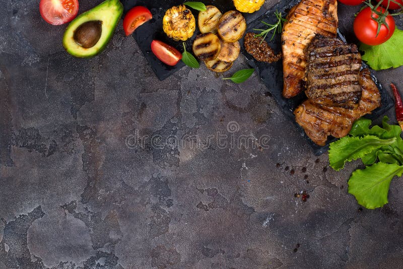 Três tipos frescos de galinha grelhada do bife, de carne de porco, de carne na placa da ardósia com ervas, de tomate, de abacate fotografia de stock Três tipos frescos de galinha grelhada do bife, de carne de porco, de carne na placa da ardósia com ervas, de tomate, de abacate fotografia de stock