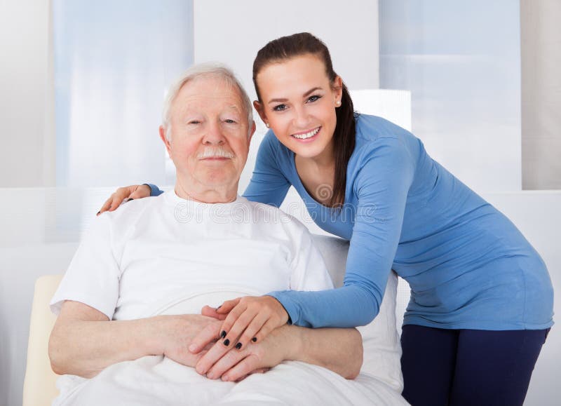 Tröstender älterer Mann der Pflegekraft lizenzfreies stockbild Tröstender älterer Mann der Pflegekraft lizenzfreies stockbild