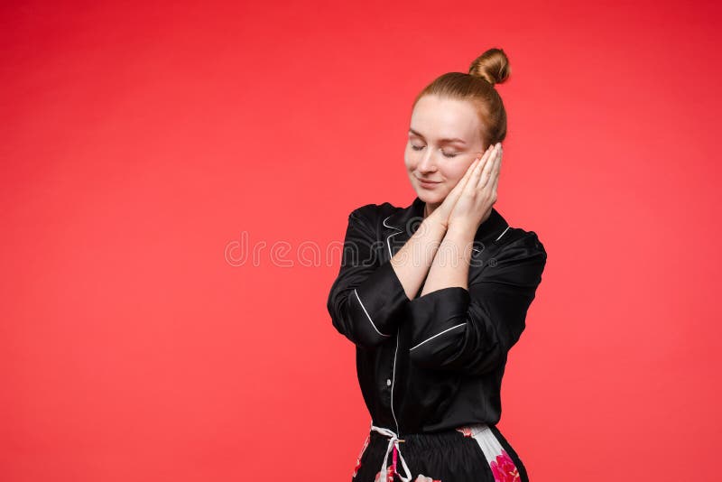 Trött kvinna i svart pyjamas som stänger ögon och att sova royaltyfri bild Trött kvinna i svart pyjamas som stänger ögon och att sova royaltyfri bild