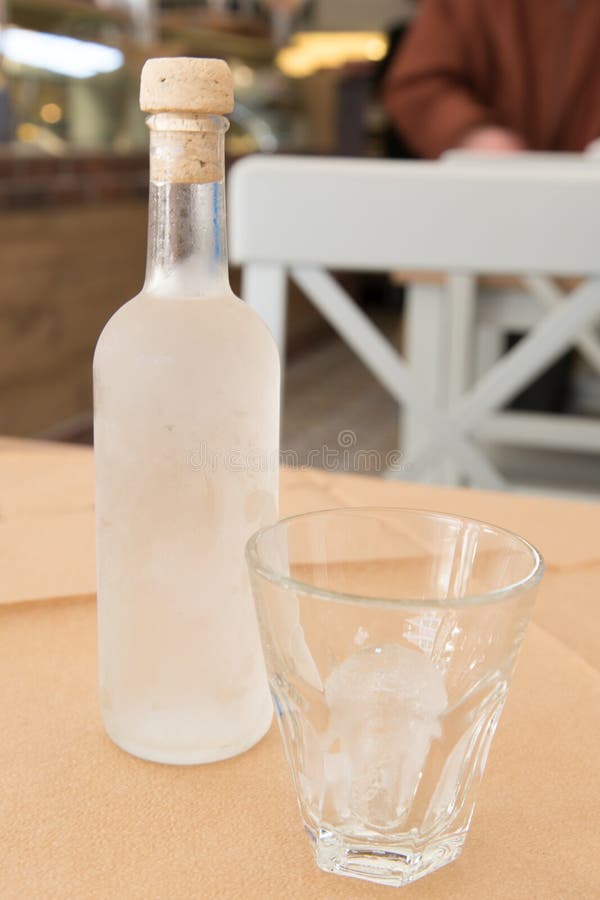 Tsipouro con un vetro con ghiaccio fotografia stock Tsipouro con un vetro con ghiaccio fotografia stock