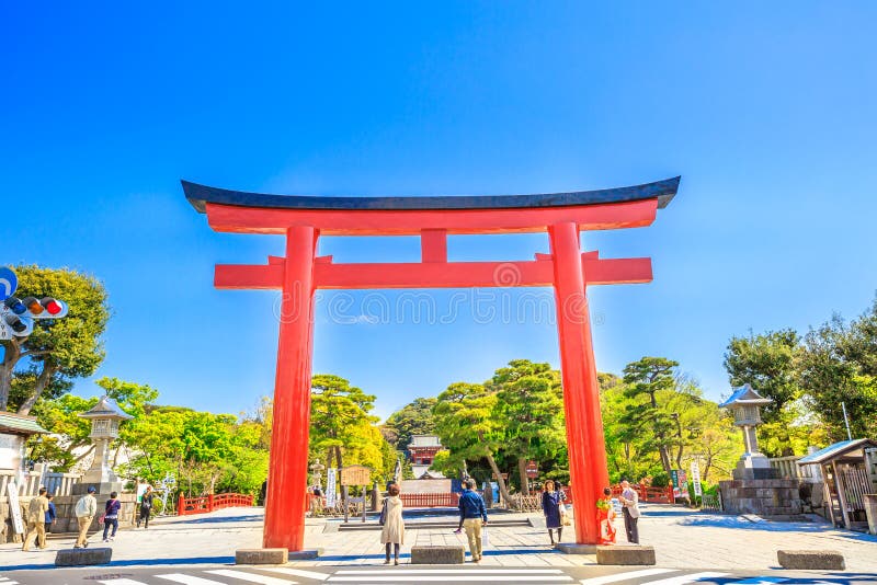 Kamakura, Japan - April 23, 2017: red torii main gate in the shrine`s entrance of Tsurugaoka Hachiman, the most important Shinto shrine in the city of Kamakura, Kanagawa Prefecture of Japan. Blue sky. Kamakura, Japan - April 23, 2017: red torii main gate in the shrine`s entrance of Tsurugaoka Hachiman, the most important Shinto shrine in the city of Kamakura, Kanagawa Prefecture of Japan. Blue sky.