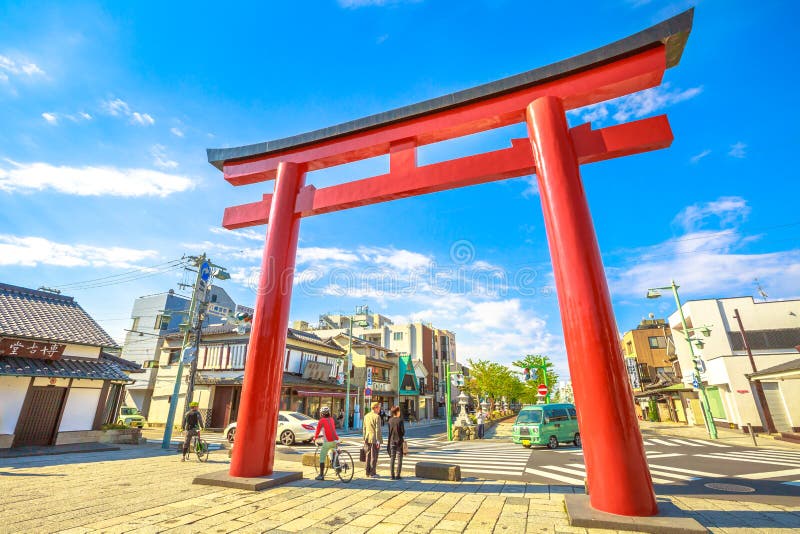 Kamakura, Japan - April 23, 2017: A giant torii gate in the shrine`s entrance of Tsurugaoka Hachiman, the most important jinja shinto sanctuary, built in 1063 in ancient Japan. Kamakura, Japan - April 23, 2017: A giant torii gate in the shrine`s entrance of Tsurugaoka Hachiman, the most important jinja shinto sanctuary, built in 1063 in ancient Japan.