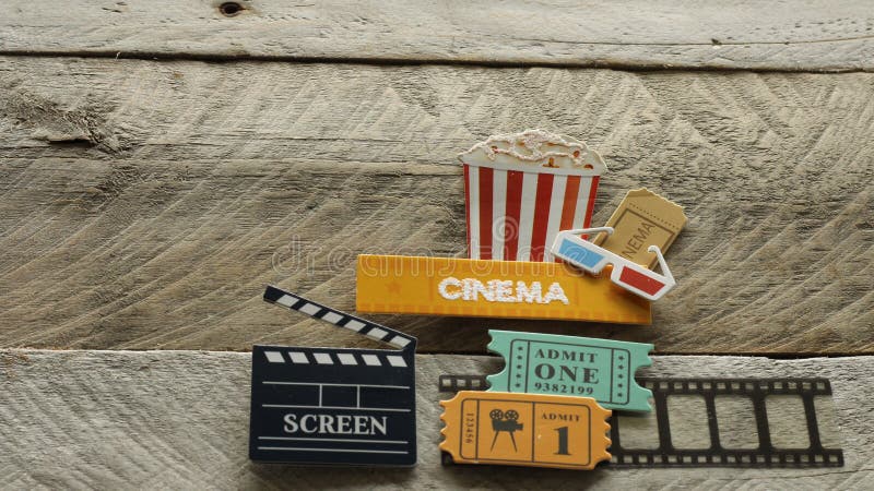 Cinema sign with popcorn bucket 3d glasses movie tickets big screen opened box on wood background