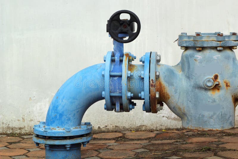 Tubature dell'acqua industriali del metallo arrugginito blu con una valvola fotografie stock Tubature dell'acqua industriali del metallo arrugginito blu con una valvola fotografie stock