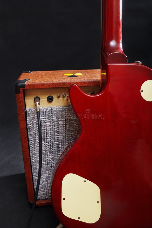 Tube Combo for Guitar with Mahogany Guitar on Black Background Stock