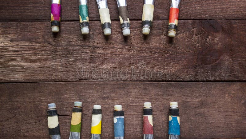 Tubes of oil paint on wooden background