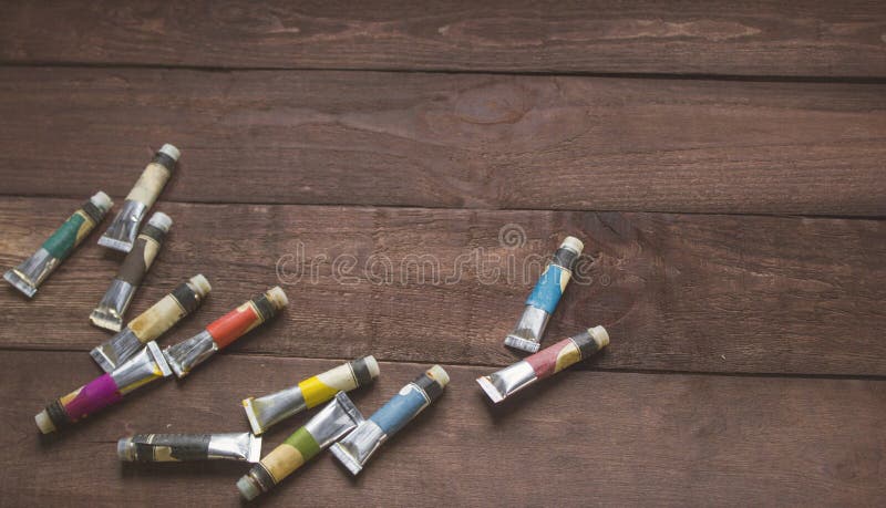 Tubes of oil paint on wooden background. Retro styled