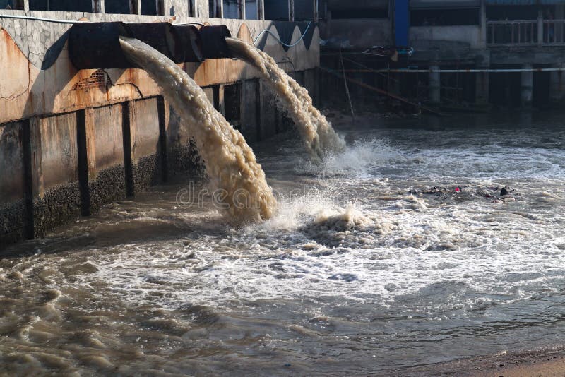 Tubo de descarga de las aguas residuales en el canal y el mar imágenes de archivo libres de regalías Tubo de descarga de las aguas residuales en el canal y el mar imágenes de archivo libres de regalías