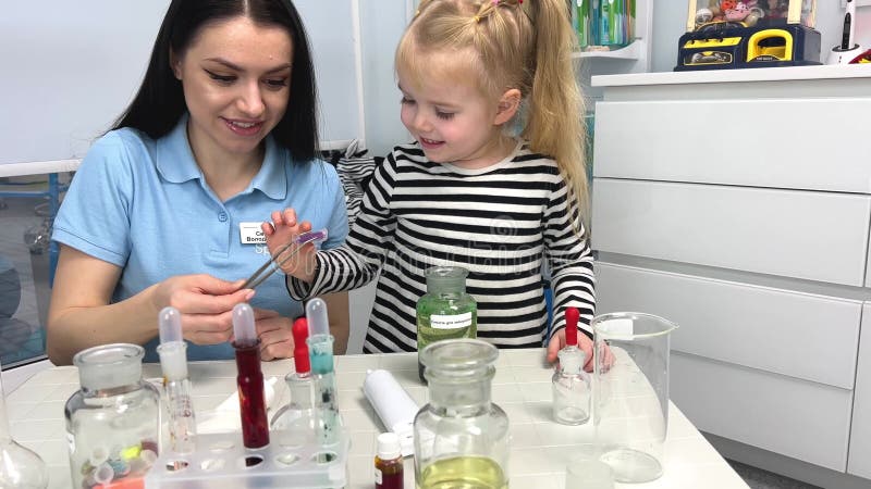 4.000 tubos coloridos de testes científicos com um fundo turvo de duas crianças se divertindo misturando cores em uma escola