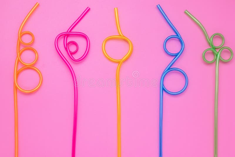 Tubos multicolores de espiral plástica en una tarjeta de papel rosa Antecedentes coloridos y curvos de los cócteles Diseño lacóni foto de archivo Tubos multicolores de espiral plástica en una tarjeta de papel rosa Antecedentes coloridos y curvos de los cócteles Diseño lacóni foto de archivo