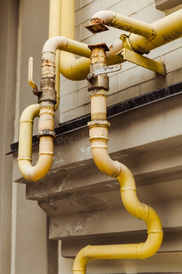 Tubula??es amarelas curvadas velhas na casa velha imagem de stock Tubula??es amarelas curvadas velhas na casa velha imagem de stock