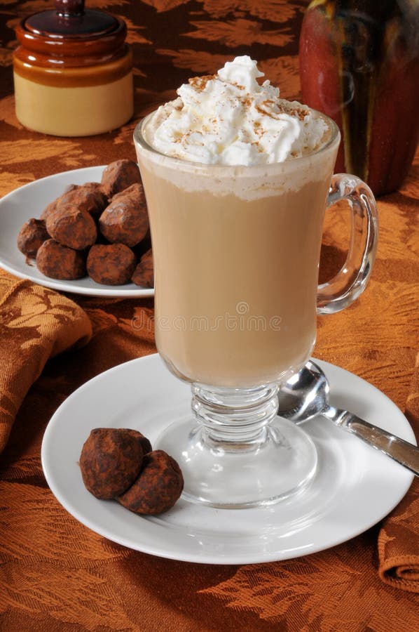 A cup of cappuccino with whipped cream and truffles. A cup of cappuccino with whipped cream and truffles