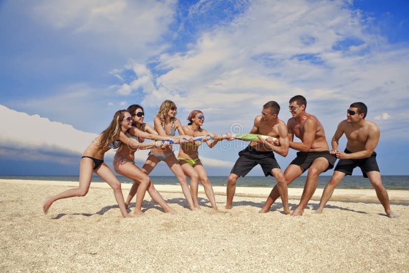 Tug-of-war between girls and guys on the beach. Tug-of-war between girls and guys on the beach