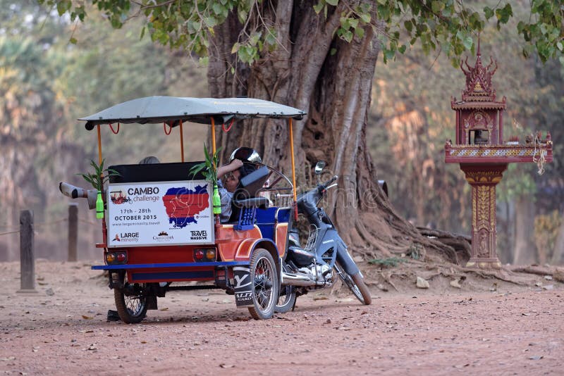 Tuk Tuk driver resting in vehicle at Bakong Temple on sunny day. Tuk Tuk driver resting in vehicle at Bakong Temple on sunny day.