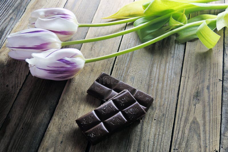 Tulip and chocolate on wooden background