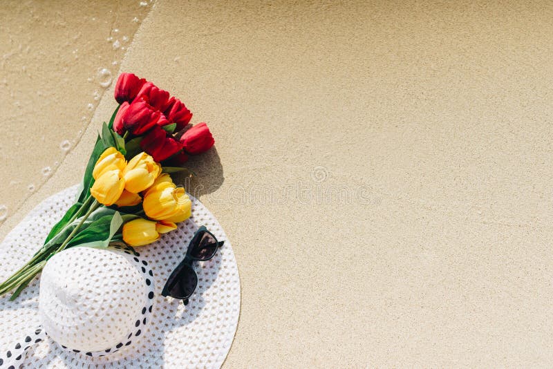 Tulpen, geel en rood deeg met witte zonhoed met zwarte zonnebril stock afbeeldingen Tulpen, geel en rood deeg met witte zonhoed met zwarte zonnebril stock afbeeldingen