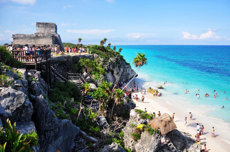Tulum, Yucatan/México - 3 de agosto de 2011: Muitos turistas na praia do paraíso com o templo El Castillo ao fundo do maia imagens de stock Tulum, Yucatan/México - 3 de agosto de 2011: Muitos turistas na praia do paraíso com o templo El Castillo ao fundo do maia imagens de stock