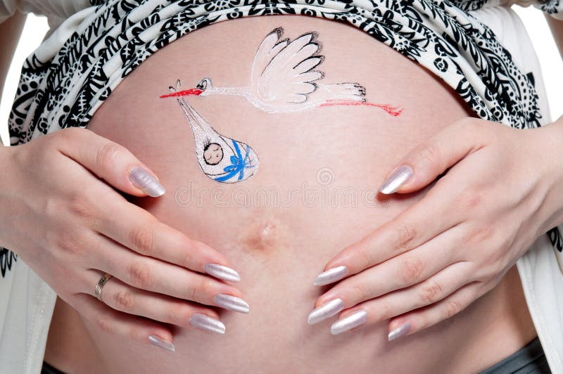 Tummy of pregnant woman with funny drawing over white background. Tummy of pregnant woman with funny drawing over white background