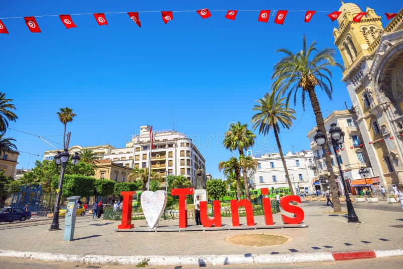 TUNIS, TUNISIA - JULY 05, 2017: Street scene in downtown on Avenue Bourguiba near cathedral of St Vincent de Paul. North Africa. TUNIS, TUNISIA - JULY 05, 2017: Street scene in downtown on Avenue Bourguiba near cathedral of St Vincent de Paul. North Africa