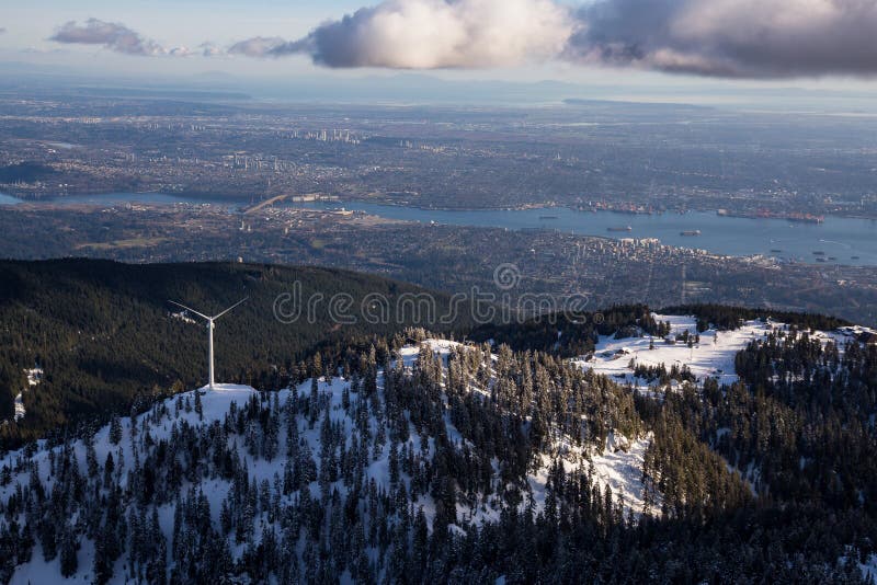 Aerial view of Grouse Mountain and Vancouver Downtown City, BC, Canada, in the background. Picture taken during a cloudy winter sunset. Aerial view of Grouse Mountain and Vancouver Downtown City, BC, Canada, in the background. Picture taken during a cloudy winter sunset.