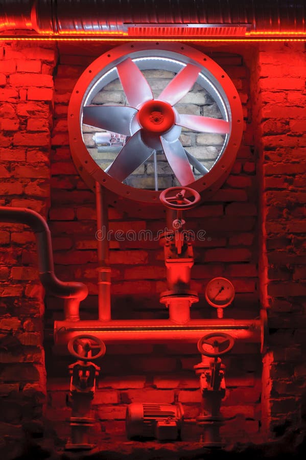 Industrial decoration with old bricks, red light and old pumps, old pipes and turbine. Turbine wheel in old factory pipes, valves with wall industrial decoration. Industrial decoration with old bricks, red light and old pumps, old pipes and turbine. Turbine wheel in old factory pipes, valves with wall industrial decoration.