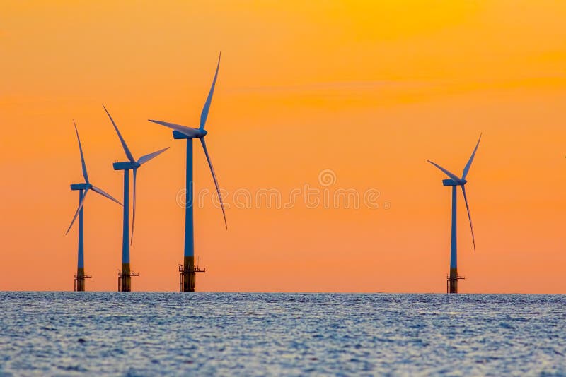 Turbinas da energia da exploração agrícola de vento a pouca distância do mar no alvorecer Surreal mas natural imagens de stock Turbinas da energia da exploração agrícola de vento a pouca distância do mar no alvorecer Surreal mas natural imagens de stock