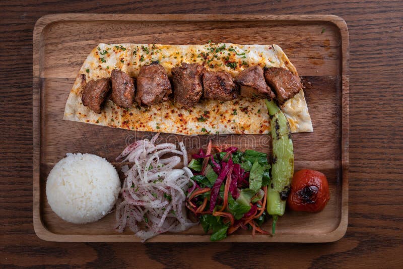 Turecki kebab z ryżem i warzywami na drewnianym stole