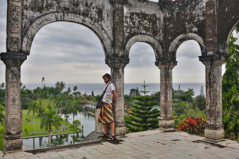 Turist för ung man i gammal vattenslott på den Bali ön royaltyfria bilder Turist för ung man i gammal vattenslott på den Bali ön royaltyfria bilder