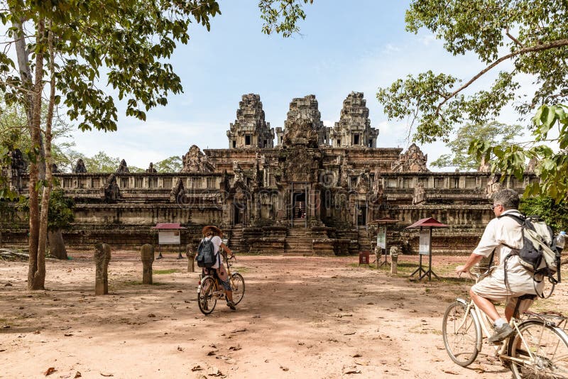 Turist- par som cyklar runt om den Angkor templet, Cambodja Byggnad f?r Ta Keo f?rd?rvar i djungeln Eco v?nlig turism som reser, arkivbilder Turist- par som cyklar runt om den Angkor templet, Cambodja Byggnad f?r Ta Keo f?rd?rvar i djungeln Eco v?nlig turism som reser, arkivbilder